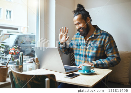 Cafe, wave or man on laptop video call planning SEO networking, conference or B2B sale. Small business or remote work employee on tech communication, social network strategy or research in restaurant Cafe, wave or man on laptop video call planning SEO networking, conference or B2B sale. Small business or remote work employee on tech communication, social network strategy or research in restaurant 131811496