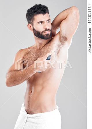 Deodorant, spray and man in studio grooming for hygiene, fresh scent or sweating smell. Male model spraying armpit of body odor, beauty cosmetics and cleaning skincare of bottle product on background 131811584