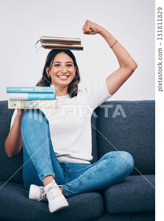 Portrait, education and success with a student woman flexing her bicep while sitting on a sofa in her home. University, books and balance with an attractive young female pupil feeling confident Portrait, education and success with a student woman flexing her bicep while sitting on a sofa in her home. University, books and balance with an attractive young female pupil feeling confident 131811829