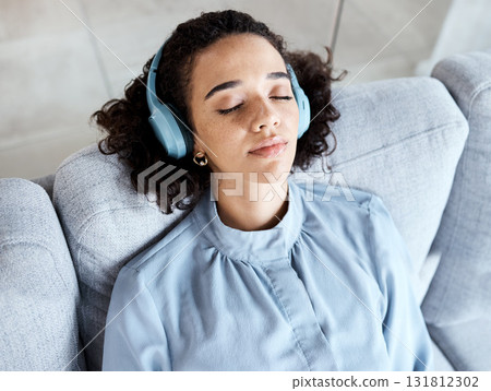 Woman, face and headphones for listening to music for calm, peace and mindfulness on home couch. Young person on living room sofa listen to podcast, audio or motivation to relax or meditation above Woman, face and headphones for listening to music for calm, peace and mindfulness on home couch. Young person on living room sofa listen to podcast, audio or motivation to relax or meditation above 131812302
