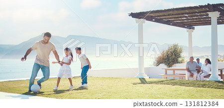 Family, father and playing football at beach on vacation, having fun and bonding. Soccer, sports and happy dad play with kids or children for exercise, care and enjoying holiday at seashore in summer 131812384