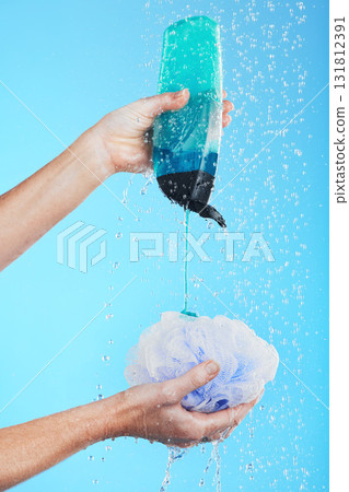 Skincare, product and hands with loofah and shower gel of person washing isolated in a studio blue background. Self care, beauty and person or model using soap and sponge for morning routine Skincare, product and hands with loofah and shower gel of person washing isolated in a studio blue background. Self care, beauty and person or model using soap and sponge for morning routine 131812391