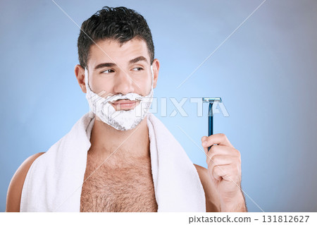 Facial, foam on beard and man with razor in hand, towel and product placement and mock in studio. Shaving cream on face, hair and skincare for happy male model grooming, isolated on blue background. Facial, foam on beard and man with razor in hand, towel and product placement and mock in studio. Shaving cream on face, hair and skincare for happy male model grooming, isolated on blue background. 131812627