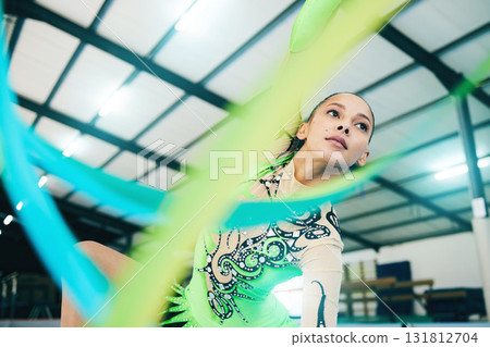 Gymnastics, ribbon dancer and woman doing a sport, fitness and dance performance in a gym. Moving, competition and exercise of a young female busy with training and dancing workout in a arena 131812704