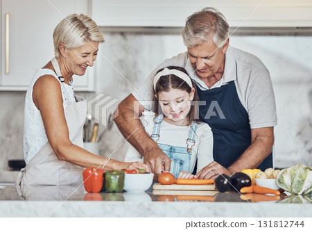 Learning, grandparents or girl cooking as a happy family in a house kitchen with organic vegetables for dinner. Grandmother, old man and child helping or cutting carrots for a healthy vegan food diet Learning, grandparents or girl cooking as a happy family in a house kitchen with organic vegetables for dinner. Grandmother, old man and child helping or cutting carrots for a healthy vegan food diet 131812744