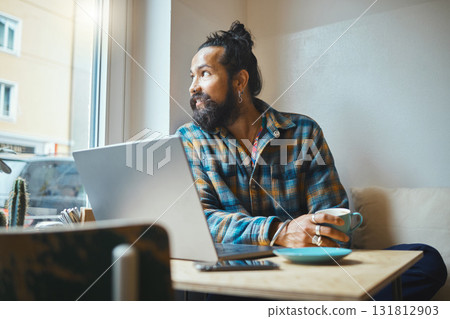 Laptop, coffee and man in a cafe working on a creative freelance project or small business strategy. Cafeteria, computer and male freelancer doing remote work while drinking a latte in a restaurant. Laptop, coffee and man in a cafe working on a creative freelance project or small business strategy. Cafeteria, computer and male freelancer doing remote work while drinking a latte in a restaurant. 131812903