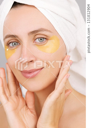 Skincare. A young Caucasian woman with under eye patches in studio for cosmetics ads. Face. Facial treatment, collagen glow. Spa, detox, beauty routine. Female portrait. Grey background. Feminine care Skincare. A young Caucasian woman with under eye patches in studio for cosmetics ads. Face. Facial treatment, collagen glow. Spa, detox, beauty routine. Female portrait. Grey background. Feminine care 131812904