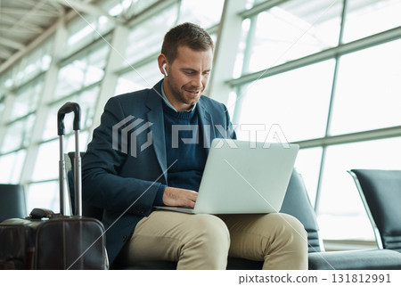 Airport, business man and laptop for music during travel or working in lobby streaming internet. Entrepreneur person with luggage in building for video call while typing email, search or news 131812991