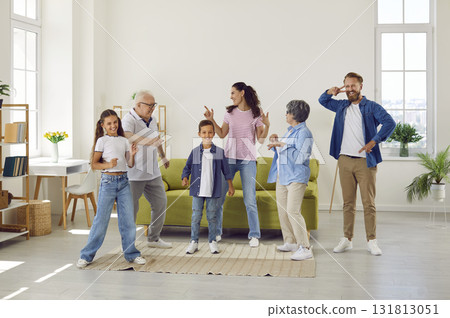 Big friendly family grandparents, parents and children dancing in living room at home. 131813051