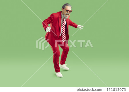 Cool stylish man with dyed gray hair and beard having fun dancing at New Year's party. Cool stylish man with dyed gray hair and beard having fun dancing at New Year's party. 131813073