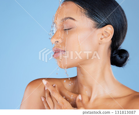 Beauty, water splash or washing face in shower grooming, healthcare or sustainability cleaning on isolated blue background. Zoom, black woman or model in wet drops for skincare hydration dermatology 131813087