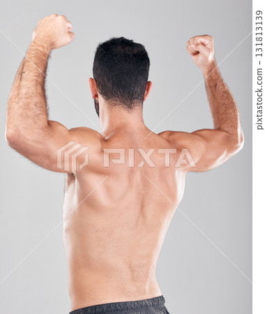 Flexing, muscle and fitness model or man with back strength after training isolated against a studio gray background. Wellness, workout and male person after exercise for body goal and biceps Flexing, muscle and fitness model or man with back strength after training isolated against a studio gray background. Wellness, workout and male person after exercise for body goal and biceps 131813139