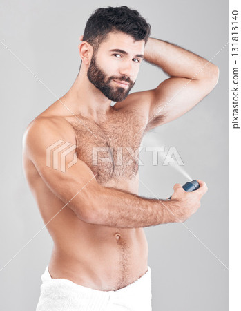 Portrait, deodorant and man spray armpit for hygiene, fresh scent and grooming isolated on a gray studio background. Cosmetics, wellness and young male model with perfume, fragrance or antiperspirant Portrait, deodorant and man spray armpit for hygiene, fresh scent and grooming isolated on a gray studio background. Cosmetics, wellness and young male model with perfume, fragrance or antiperspirant 131813140