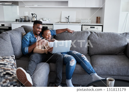 Couple, laptop and watch movie while lying on the living room couch for relaxation. Internet, pc and online social media browsing with an african american man and woman using a laptop for streaming Couple, laptop and watch movie while lying on the living room couch for relaxation. Internet, pc and online social media browsing with an african american man and woman using a laptop for streaming 131813179