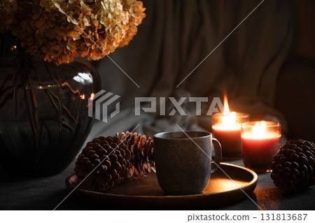 Cozy interior with coffee, aroma candles served in living room. Autumn moody. Scandinavian home decoration. Close up. Cozy interior with coffee, aroma candles served in living room. Autumn moody. Scandinavian home decoration. Close up. 131813687