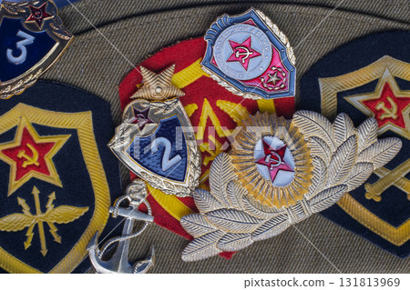 Russian Soviet military cap with military medals and patches. Green cap with several medals honoring top service and three patches all with ruby stars and hammer and sickle emblems. Hero of Country 131813969