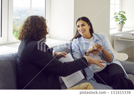 Young business people man and woman having meeting at office sitting on sofa and talking. 131815336