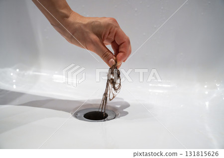Water drain hole in bath is clogged with hair clump in bathroom at home. Water drain hole in bath is clogged with hair clump in bathroom at home. 131815626