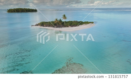 This scene showcases a beautiful tropical island featuring sandy beaches and lush palm trees, set against a backdrop of serene turquoise waters. 131815757