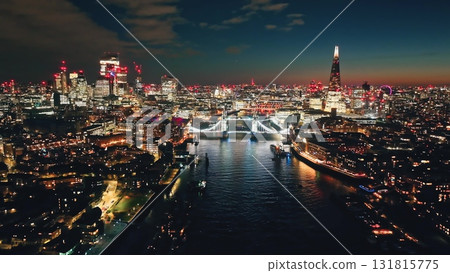 England, London: Illuminated Tower Bridge at night, city lights of London skyline at dusk featuring iconic landmark attraction The Shard and River Thames under colorful sky. Aerial view drone panorama England, London: Illuminated Tower Bridge at night, city lights of London skyline at dusk featuring iconic landmark attraction The Shard and River Thames under colorful sky. Aerial view drone panorama 131815775
