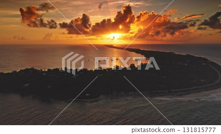 Fakarava Atoll: bright sunset illuminate South Pacific Ocean with sailboats inside the island lagoon silhouette and dramatic orange clouds during golden hour in French Polynesia. Aerial drone Fakarava Atoll: bright sunset illuminate South Pacific Ocean with sailboats inside the island lagoon silhouette and dramatic orange clouds during golden hour in French Polynesia. Aerial drone 131815777