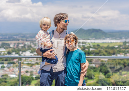 Father with his two sons standing in front of Popocatepetl volcano in Mexico, surrounded by clouds, enjoying a scenic family adventure and breathtaking outdoor view 131815827