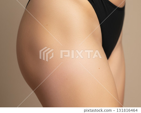 Close-up, textured studio shot of a woman's thigh and hip area, showcasing smooth, even skin texture, ideal for representing a successful cellulite smoothing or body contouring treatment 131816464