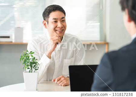 接待員，一位中年亞洲男子正在與櫃檯銷售員交談 131817238