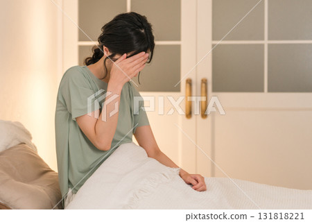 Young Asian woman suffering from headache after waking up in bedroom 131818221