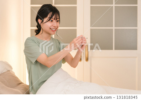 Young Asian woman feeling unwell taking her temperature in bed (smile, recovery, normal temperature, cured) Young Asian woman feeling unwell taking her temperature in bed (smile, recovery, normal temperature, cured) 131818345