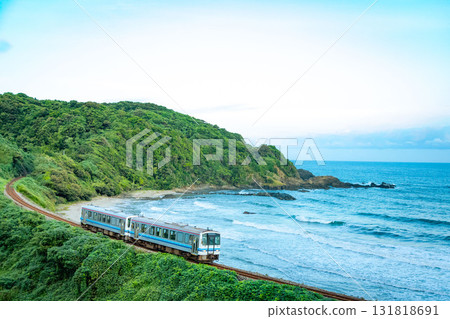 一列當地火車在晨曦中沿著海岸行駛 131818691