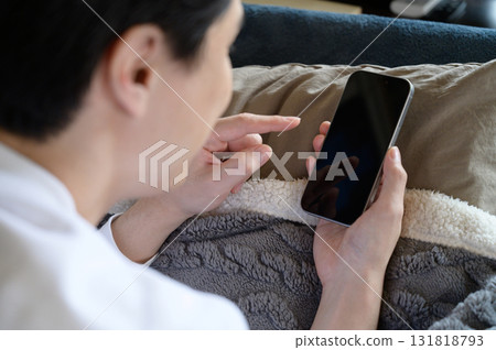 一個人在床上操作智能手機 一個人在床上操作智能手機 131818793