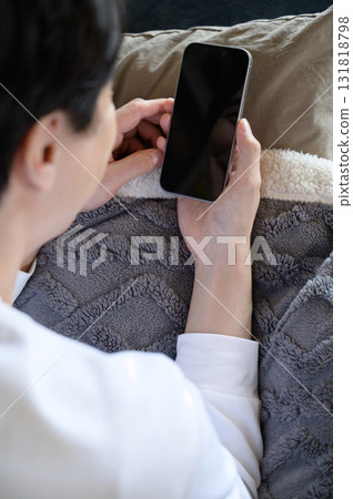 A man operating a smartphone in bed A man operating a smartphone in bed 131818798