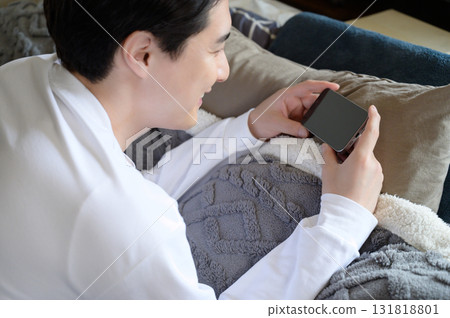 A man operating a smartphone in bed A man operating a smartphone in bed 131818801