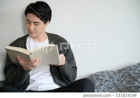 男人坐在床上看書 131819106