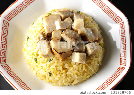 Egg fried rice topped with diced pork slices photographed against a black background Egg fried rice topped with diced pork slices photographed against a black background 131819706