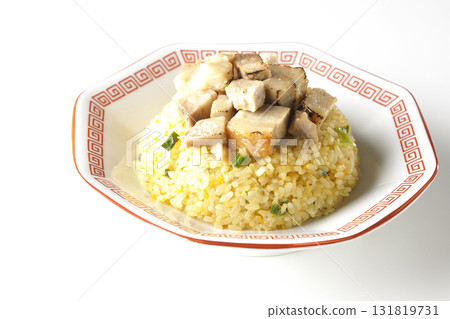 Egg fried rice topped with diced pork slices photographed against a white background 131819731