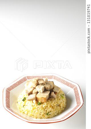 Egg fried rice topped with diced pork slices photographed against a white background Egg fried rice topped with diced pork slices photographed against a white background 131819741
