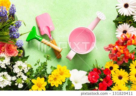A bright and lively balcony showcases a variety of spring flowers in full bloom. Gardening tools are arranged artfully among the colorful petals, inviting creativity and joy 131820411