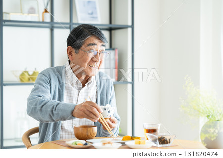 Senior man eating breakfast 131820474