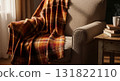 Armchair with Orange Plaid Blanket and Side Table in Cozy Room Setting 131822110