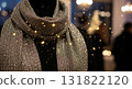 Elegant Silver Glitter Scarf Displayed on Black Mannequin with Sparkling Overlay and Blurred 131822120