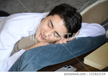 A man taking a nap face down in bed 131822134