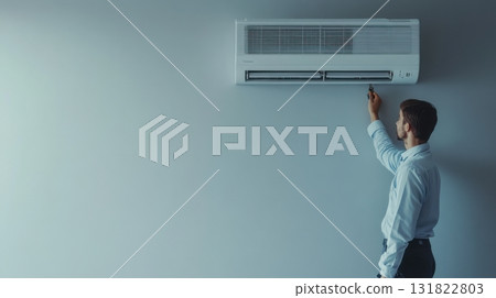 Technician performs maintenance on a wall-mounted air conditioning unit in a modern office setting 131822803