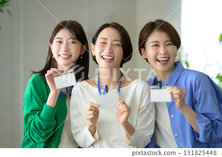 Three women lined up wearing nameplates 131825448