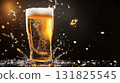 Refreshing beer splashing in a glass against a dark background, highlighting the golden color and bubbles 131825545