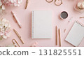 Stylish workspace setup with blank notebook, coffee, and stationery on a pink background during afternoon light 131825551