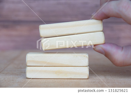 Hand pushing wooden blocks with customizable space for text or ideas. Copy space concept. Hand pushing wooden blocks with customizable space for text or ideas. Copy space concept. 131825621