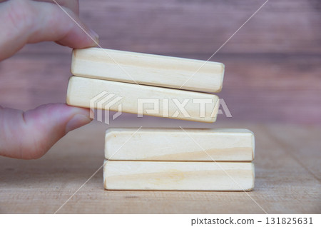 Hand pushing wooden blocks with customizable space for text or ideas. Copy space and advertisement concept. Hand pushing wooden blocks with customizable space for text or ideas. Copy space and advertisement concept. 131825631