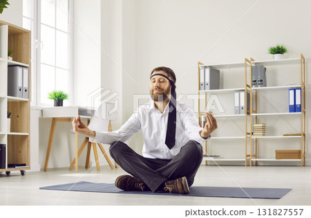 Funny business man with necktie around his head relaxing and doing meditation on office floor 131827557